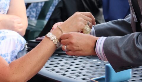 Tim wins the diamond bracelet and places it on his wife's wrist. Sweet!