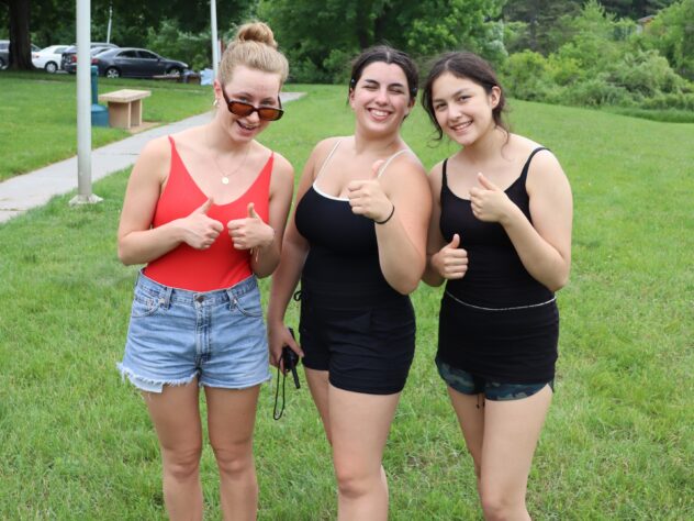 Three girls giving "thumbs up" sign