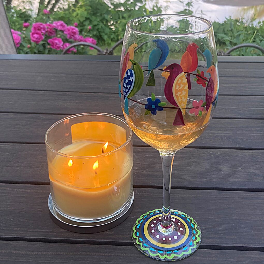 Dinner on the deck at the Hadrath House with a candle, glass of wine, and the Saint Croix River in the background