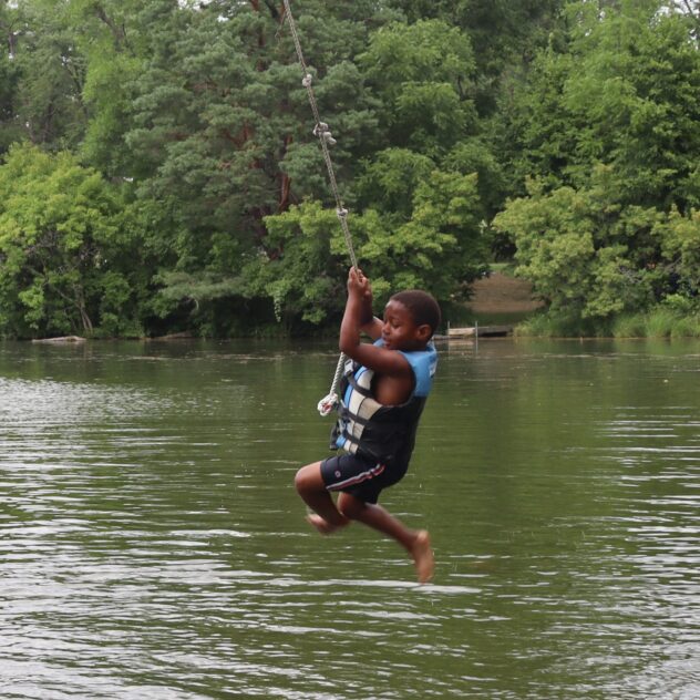 Boy jumping off rope swing